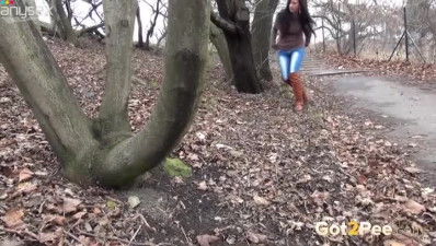 Kinky long haired brunette gal pulls down jeans and pisses outdoors