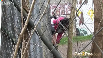 Raven haired dirty teen loves pissing on wire fence