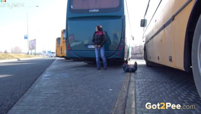 Dark haired filthy girl pisses backwards of big bus