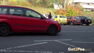 Raven haired filthy gal makes pees between two cars outdoors