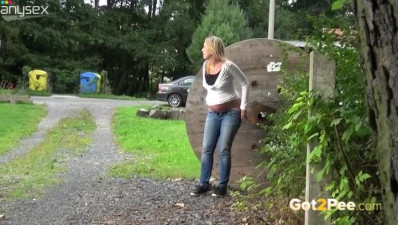 Light haired bonny harlot in jeans pisses sitting on ground