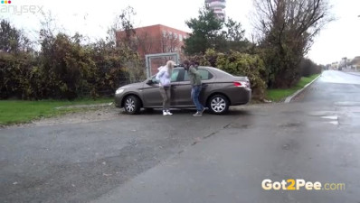 Two shameless teen bitches piss a lot near luxury car of their neighbor