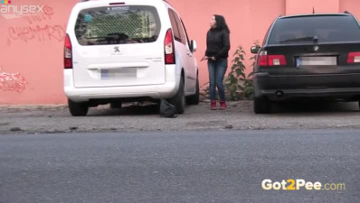 Dark haired filthy chick in red sneakers pisses near car outdoors