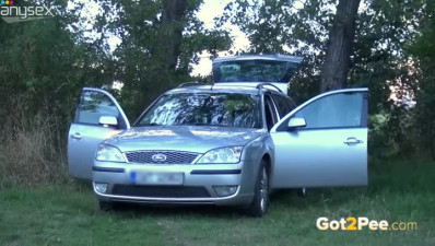 Freaky blond chick sits on the hood of her car and pisses right away