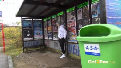 Slutty blond chick in sports suit performs wet solo at bus stop