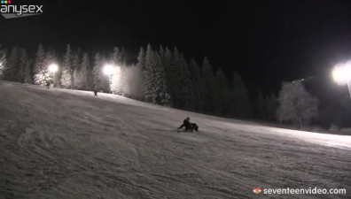 Playful teens Linda and Lilly are passionately kissing while skiing at night