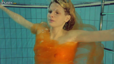 Pretty hot red head Nastya is stripping under the water