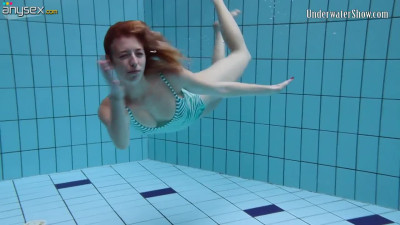 Sweet looking red head Anetta is stripping under the water