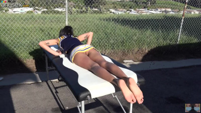 Cheerleader without panties sunbathing on the massage table